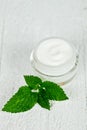 Face cream in glass jar with green leaf of urtica