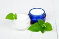 Face cream in jars with urtica leaves