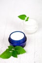 Face cream in jars with urtica leaves