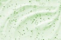 Face cream scrub texture background. Green color exfoliating skincare product smear