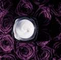 Face cream skin moisturizer on purple roses flowers, luxury skincare cosmetic product on floral background as beauty brand holiday Royalty Free Stock Photo