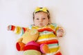 Face of cute surprised baby infant girl in colored pajamas with a bow on her head, making funny mouth expression. Royalty Free Stock Photo