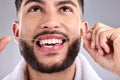 Face, dental and man floss teeth in studio isolated on a white background. Tooth, flossing product and male model