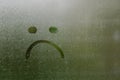 Face expession as boring and sad painted on window which fogged up after rain Royalty Free Stock Photo
