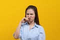 Face expression of human. Asian female smelling disgusted odor and pinching his nose in studio shoot yellow background