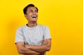 Face expression of human. Asian male laughing in studio shoot yellow background