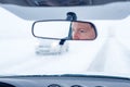 Face of a female driver in car rear-view mirror while driving in bad conditions during snow blizzard Royalty Free Stock Photo