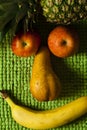 Face fruit smile. Apple, pear, pineapple and banana. Plush green background.