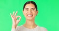 Face, green screen and woman with ok sign, smile and approval against a studio background. Portrait, female and person
