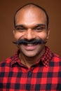 Face of happy Indian hipster man with mustache