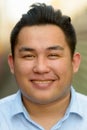 Face of happy overweight Asian tourist man smiling at railway train station