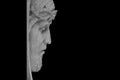 Face of Jesus Christ in a crown of thorns against black background. Fragment of an ancient statue. Profile image Royalty Free Stock Photo