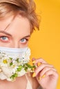 Face mask design with flowers. Portrait of beautiful woman with blue eyes, fashion make-up and mask on the orange Royalty Free Stock Photo