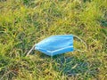 A face mask dumped on a field. Concept: Waste garbage during covid 19, coronavirus