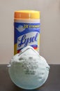 A face mask in front of a Lysol cleaner