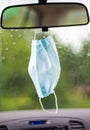 Face mask hanging inside a car on a mirror Royalty Free Stock Photo