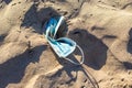 Abandoned used face mask on the beach with outdoor sun lighting Royalty Free Stock Photo