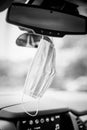 Black and white Face mask PPE in car hanging from rear view mirror Royalty Free Stock Photo