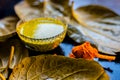 Face mask for preventing acne on a black wooden surface of betel leaves and turmeric powder.