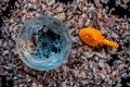 Face mask for smooth skin consisting of supari or betel nut along with some turmeric powder and water on a black wooden surface.