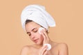 Face mask, spa beauty treatment, skincare. Woman facial care. Beautiful young woman touching cheek with sponge. Portrait