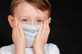 Face of a mask-wearing boy with fear in the eye Close-up on a gray background. Coronavirus and Air pollution concept Royalty Free Stock Photo