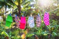 Face masks with different style prints hang and dry on clothespins outdoors at sunset