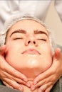 Face massage. Beautiful caucasian young white woman having a facial massage with closed eyes in a spa salon. Royalty Free Stock Photo