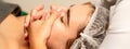 Face massage. Beautiful caucasian young white woman having a facial massage with closed eyes in a spa salon. Royalty Free Stock Photo