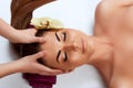 Face massage. Close-up of young woman getting spa massage treatment at beauty spa salon.Spa skin and body care. Royalty Free Stock Photo