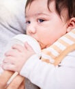 Face, milk and a baby drinking from a bottle closeup with a parent for health, diet or nutrition. Food, formula or Royalty Free Stock Photo