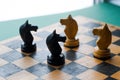 Face Off. Chess pieces knights facing each other for a standoff on chessboard with blue background. Royalty Free Stock Photo