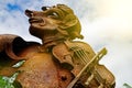 Face of an old rusty statue with iron violin