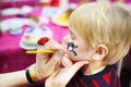 Face painting for cute little boy during kids birthday party Royalty Free Stock Photo