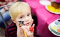 Face painting for cute little boy during kids birthday party Royalty Free Stock Photo