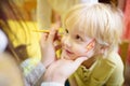 Face painting for cute little boy during kids merriment Royalty Free Stock Photo