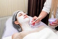 Face peeling mask, spa beauty treatment, skincare. Woman getting facial care by beautician at spa salon Royalty Free Stock Photo