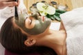Face peeling mask, spa beauty treatment, skincare. Woman getting facial care by beautician at spa salon,  close-up.Spa clay mask o Royalty Free Stock Photo