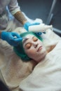 Face peeling mask, spa beauty treatment, skincare. Woman getting facial care by beautician at beauty salon. Royalty Free Stock Photo