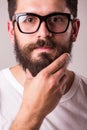 Face portrait of bearded man in glasses with hand on beard Royalty Free Stock Photo