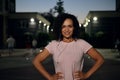 Face portrait of beautiful African American sporty woman with earphones smiling looking at camera with hands on waist Royalty Free Stock Photo