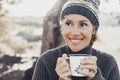 Face portrait of cheerful middle age pretty woman drinking cup of tea or coffee in outdoor leisure activity alone. Smiling lady Royalty Free Stock Photo