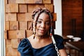 Face portrait of lovely african american woman with dreadlocks at cafe. Beautiful cool fashionable black young girl indoor Royalty Free Stock Photo