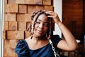 Face portrait of lovely african american woman with dreadlocks at cafe. Beautiful cool fashionable black young girl indoor Royalty Free Stock Photo