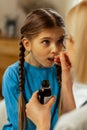 Face portrait of a small girl taking vapid cough syrup Royalty Free Stock Photo