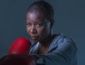 Face portrait of young angry and defiant black afro American sport woman in boxing gloves training and posing as a dangerous figh Royalty Free Stock Photo