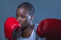 Face portrait of young angry and defiant black afro American sport woman in boxing gloves training and posing as a dangerous figh Royalty Free Stock Photo