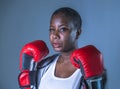 Face portrait of young angry and defiant black afro American sport woman in boxing gloves training and posing as a dangerous figh