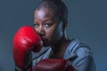 Face portrait of young angry and defiant black afro American sport woman in boxing gloves training and posing as a dangerous figh