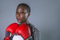 Face portrait of young angry and defiant black afro American sport woman in boxing gloves training and posing as a dangerous fight